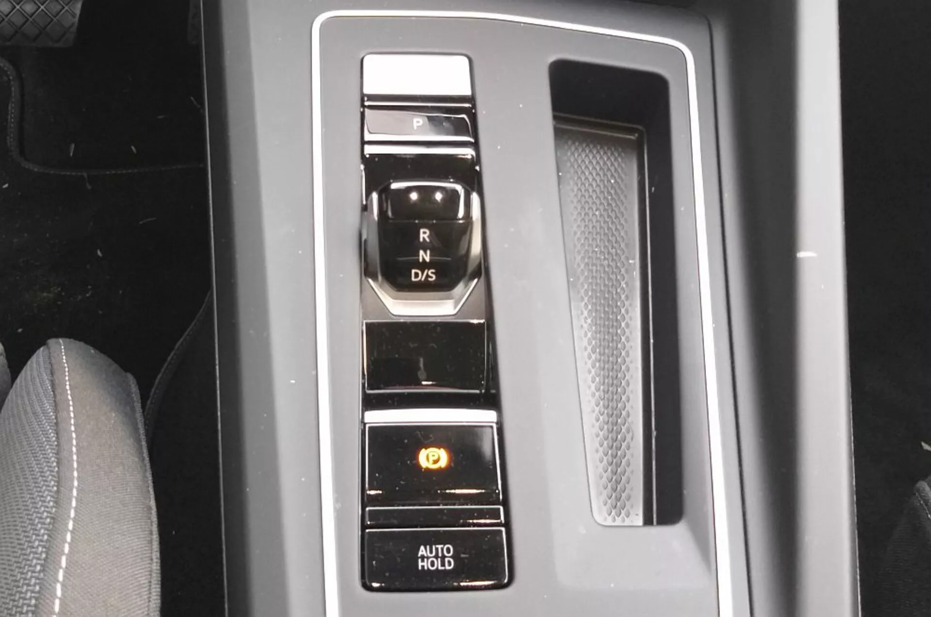 Közeli nézet a 2017-es VW Golf GTD elektronikus választókarjára, amely vertikális gombelrendezéssel rendelkezik egy zongoralakk fekete panelen krómaccentusokkal, bemutatva a modern átviteli rendszer technológiáját és kényelmi funkcióit, mint a parkolófék és az AUTO HOLD funkció