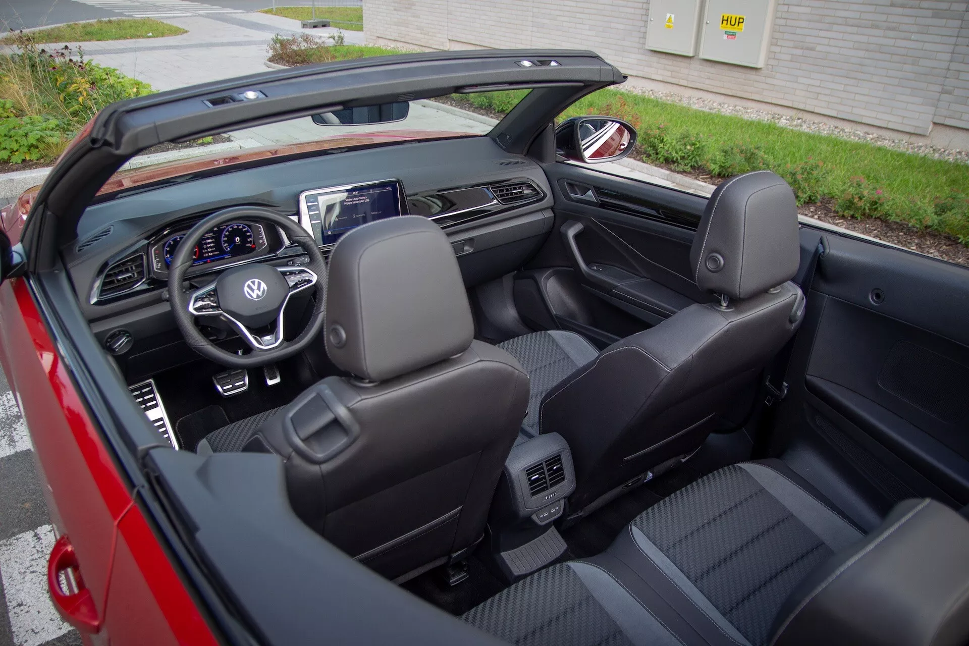 2022-es VW T-Roc Cabriolet kabrió autó belső térképe a tető visszahúzva, fekete bőr ülésekkel, multifunkciós kormánnyal, digitális műszerfallal és központi infotainment kijelzővel, kissé jobbra döntött felső nézetből