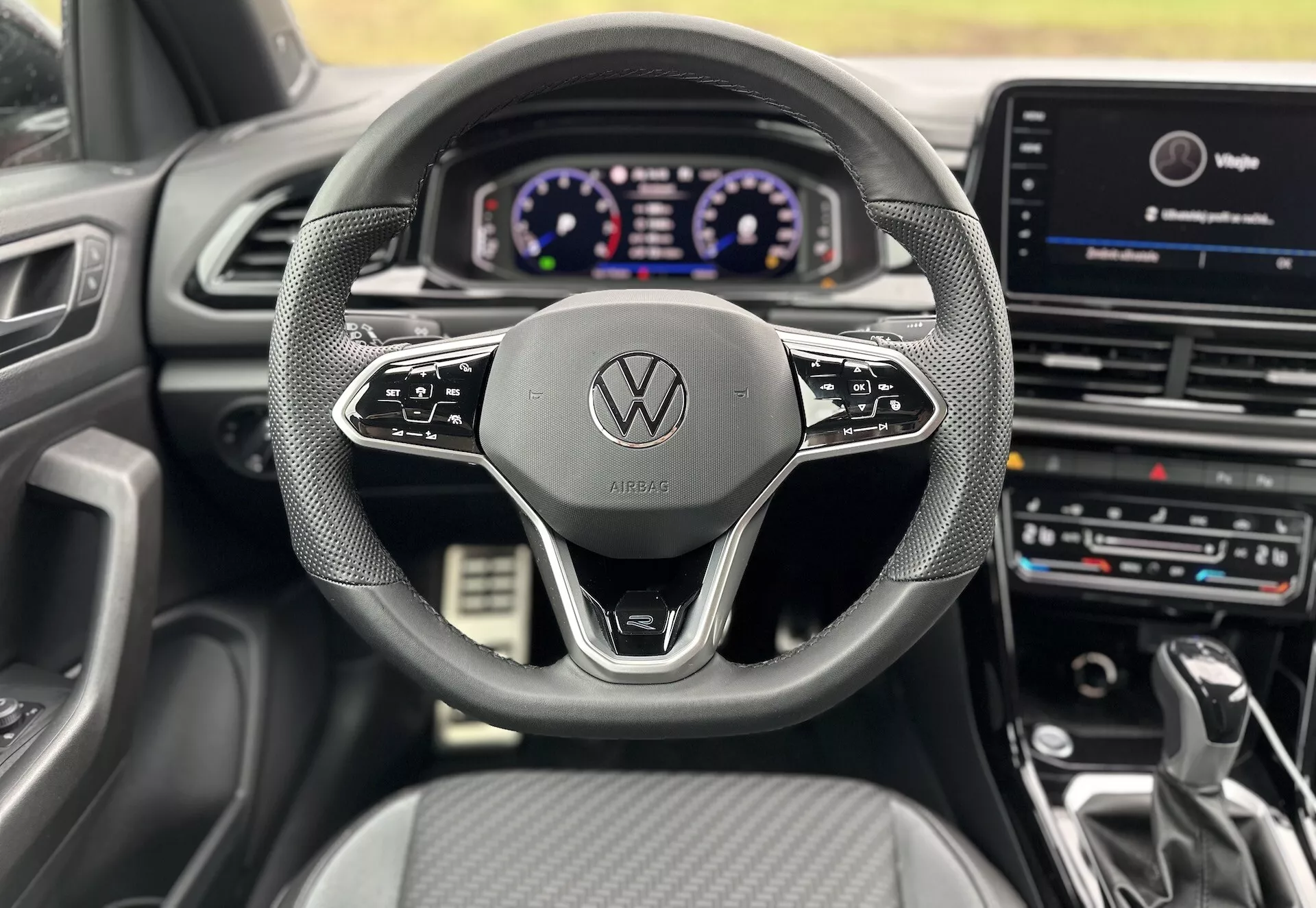 A vezető üléséből készült belső nézet egy 2022-es Volkswagen T-Roc Cabriolet-ről, amely bemutatja a kormánykereket, a digitális műszerfalt és a központi infotainment rendszert