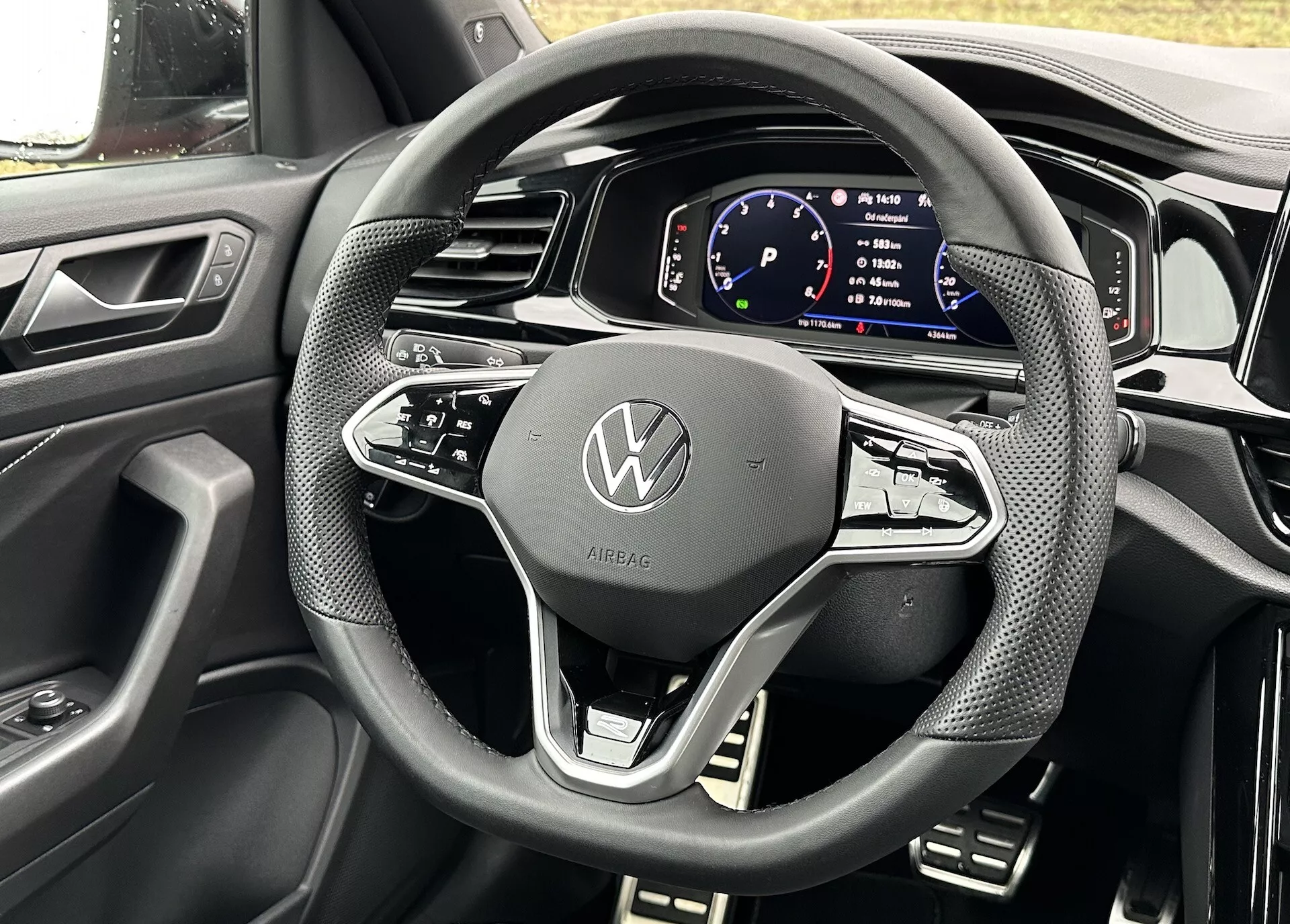 Részletes nézet a Volkswagen T-Roc 2022 Cabriolet kormánykerékéről és digitális műszerfaláról a vezető üléséből nézve, bemutatva a modern dizájnt és technológiai jellemzőket