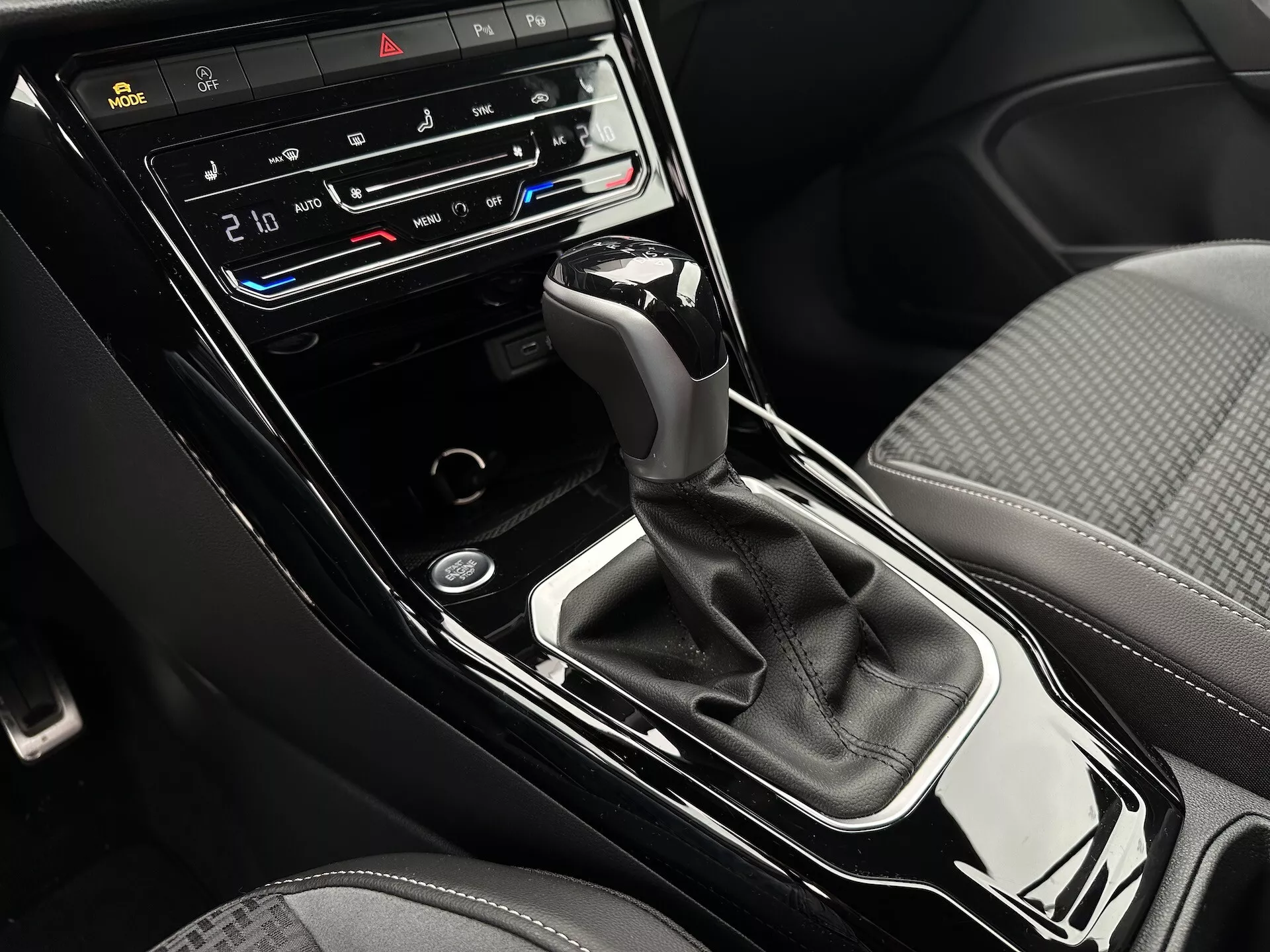 Közeli nézet a VW T-Roc Cabriolet 2022 középkonzoljára automatikus váltókar, kétzónás klímavezérlés, ülésfűtés és -hűtés gombokkal, valamint vezérlőkijelzővel