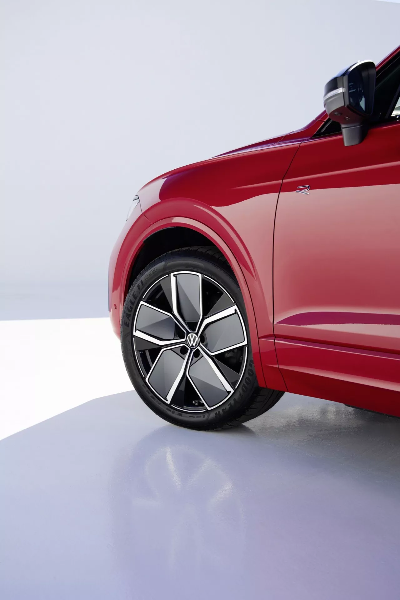 2023-as VW Touareg Facelift vezető oldali első negyed részletének megjelenítése, kiemelve az ötvözet kerék, alacsony profilú abroncs és a dinamikus karosszéria vonalakat professzionális stúdió világítás alatt